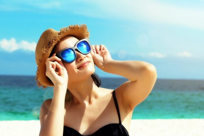 Young,Female,Fashion,Model,Smiling,And,Wearing,Big,Sunglasses,On